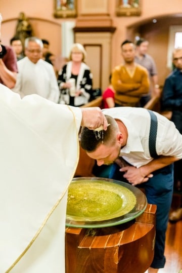 Fr Alan Gibson CM baptises Luke Gromek at St Vincent's Church. Photo: Alphonsus Fok