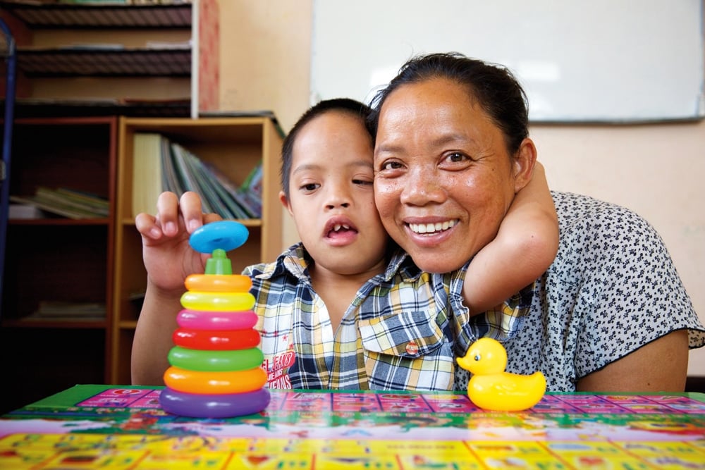 Hum Noy pictured with his mother Duangmala at the Intellectual Disabilities Unit in Vientiane, Laos.  He is learning communication skills and improving his levels of concentration by using toys, books and flash cards with pictures, symbols and words. Photo: Richard Wainwright/Caritas Australia