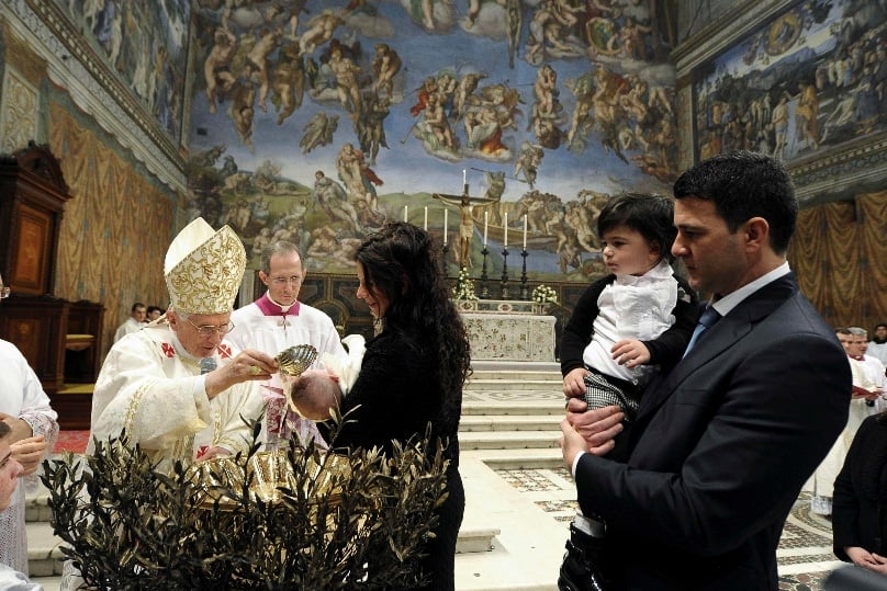 Pope Benedict XVI baptises a baby during a Mass in the Sistine Chapel at the Vatican in January 2013. Photo: CNS/L'Osservatore Romano via Reuters