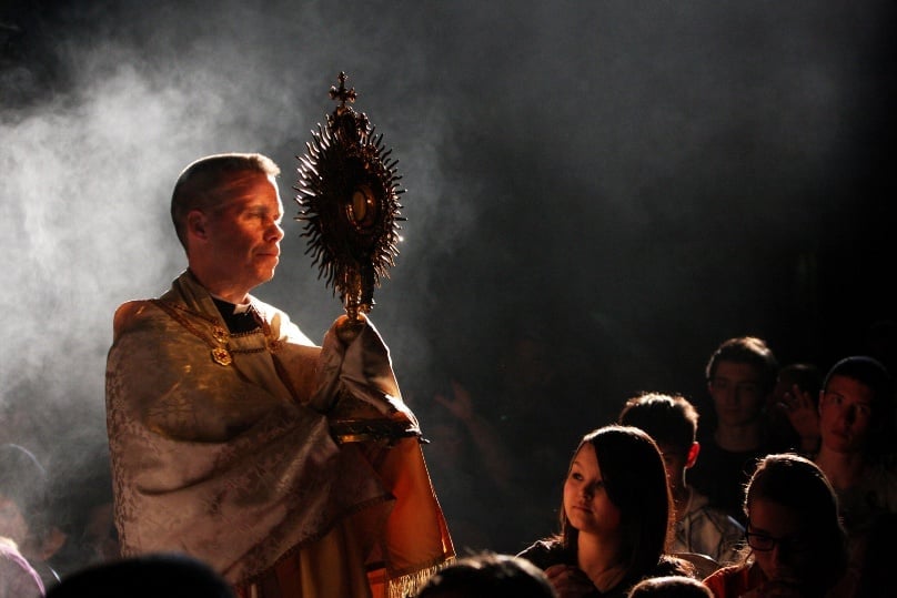 A priest presides at Eucharistic Adoration during a prayer service for vocations. Photos: Gregory Shemitz 