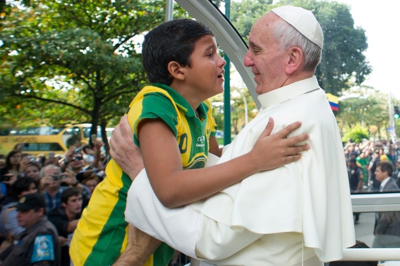 Pope Francis embraces a boy as he arrives at a park to hear confessions in Rio de Janeiro during World Youth Day in the Brazilian city in July 2013. The boy had evaded security personnel to make his way to Pope Francis in order to tell him he wanted to be a priest. Photo: L’Osservatore Romano, CNS