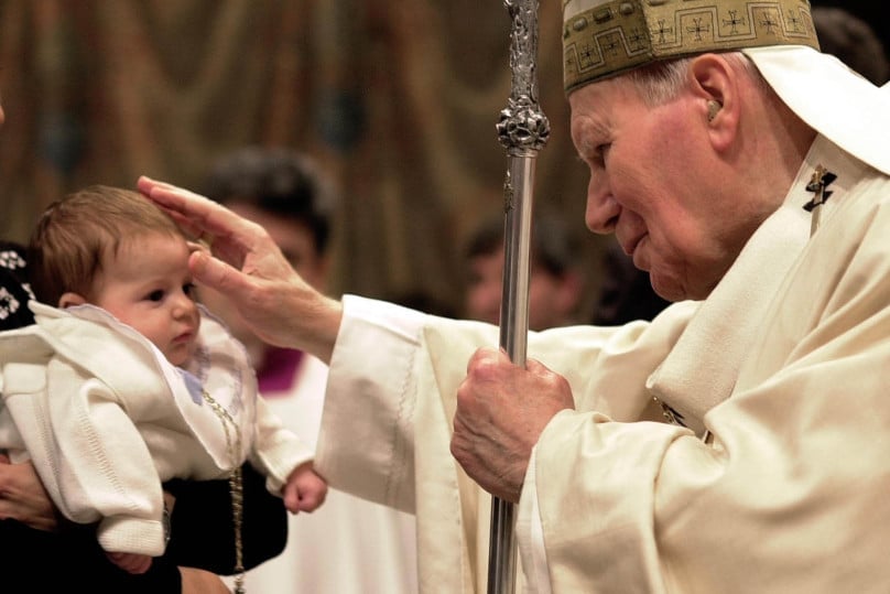 Pope John Paul II blesses a baby in the Sistine Chapel on the feast of the Baptism of the Lord in 2002. Photo: CNS/Catholic Press Photo