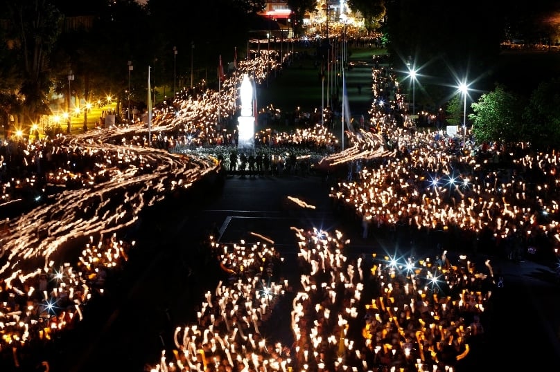 Military members from 36 nations raise candles as others arrive in procession for a candlelight vigil at the Shrine of Our Lady of Lourdes in southwestern France in May 2014. Photo: CNS/Paul Haring