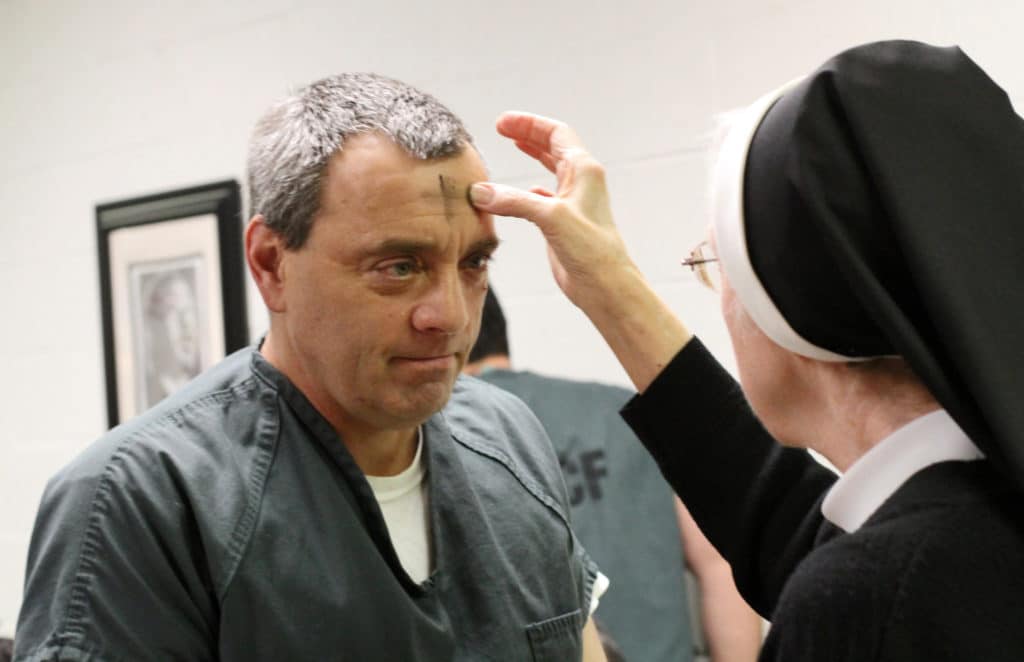 An inmate receives ashes from Sister Michelle Bremer, a member of the Congregation of the Sisters of the Holy Family of Nazareth, during an Ash Wednesday Mass at the Suffolk County Correctional Facility in New York in February 2015. Photo: CNS/Gregory A. Shemitz