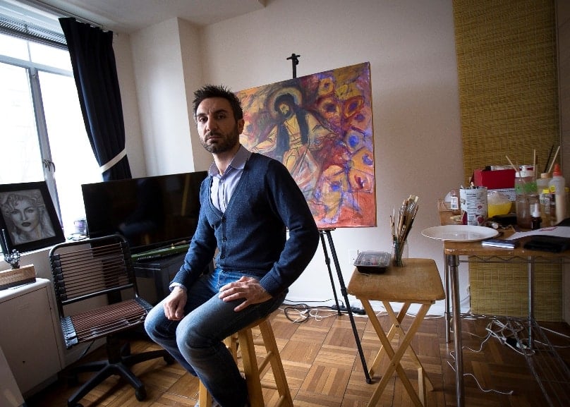 Essa Neima poses for a photo in his art studio in Washington. The Syrian artist said he got the idea to showcase his country's struggles after extremists killed a Jesuit priest friend there. Photo: CNS/Tyler Orsburn