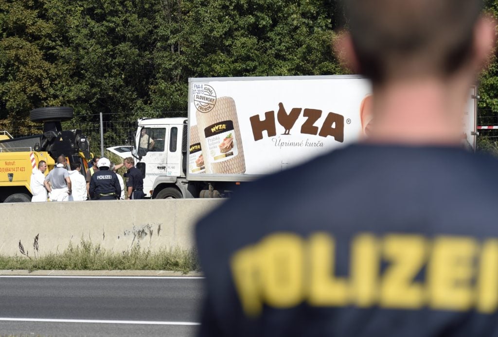 Forensic experts investigate a truck in which refugees were found dead on a freeway between Parndorf and Neusiedl, Austria. Photo: CNS/Herbert P. Oczeret