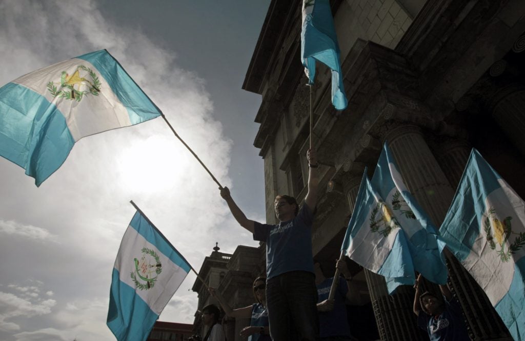 Guatemalan demonstrators wave national flags as they ask Guatemalan President Otto Perez Molina to resign during a protest in front of the National Palace of Culture in Guatemala City. Photo: CNS/Esteban Biba, EPA