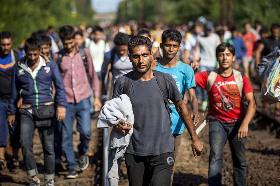 Migrants walk on the railway tracks in Bicske, Hungary, near the Austrian border on 4 September. Photo: CNS/Balazs Mohai, Reuters