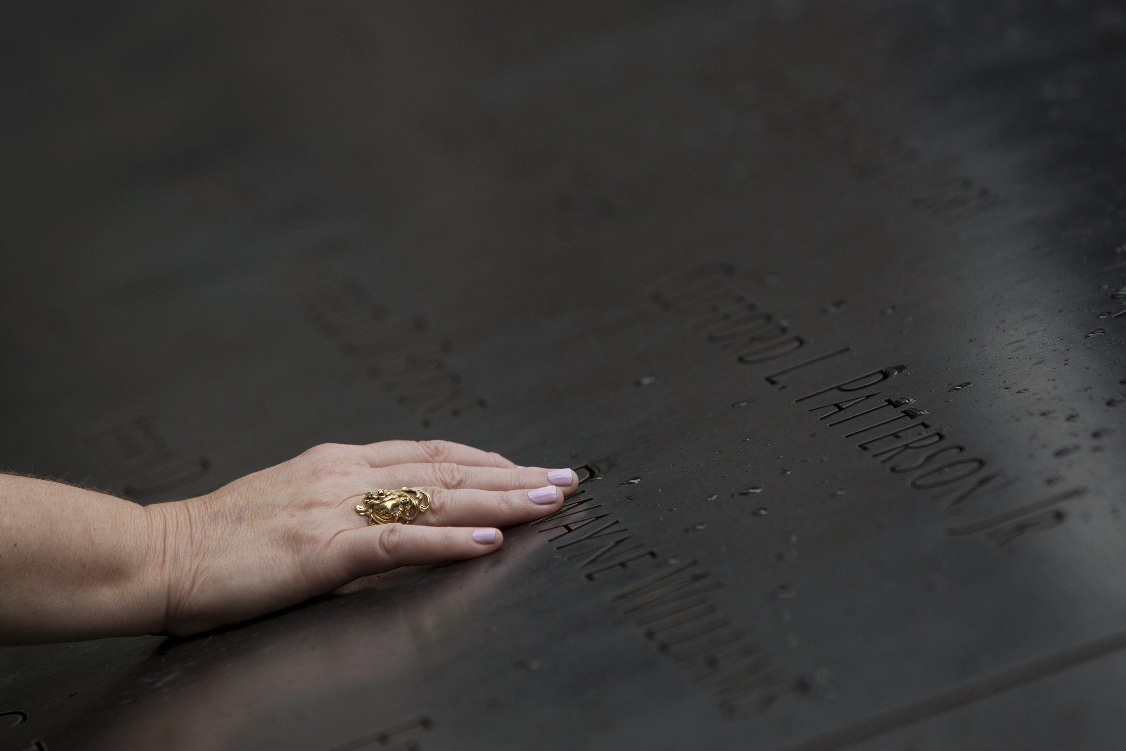 A woman touches the names at the National September 11 Memorial and Museum in New York City. The 2001 terrorist attacks claimed the lives of nearly 3000 people in New York City, Shanksville, Pennsylvania, and at the Pentagon. Photo: CNS/Andrew Kelly, Reuters