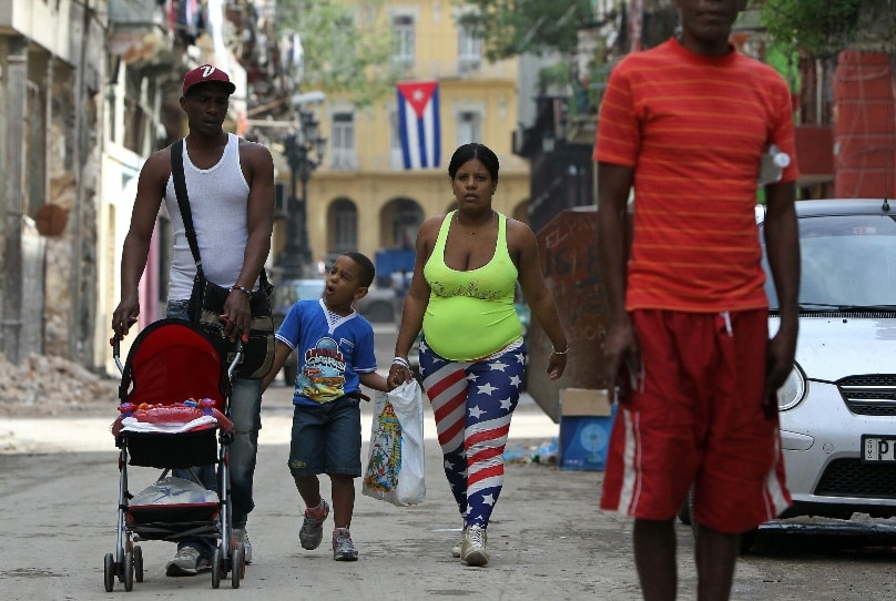 In this 2014, file photo, a family walks down a street in Havana. Photo: CNS/Alejandro Ernesto, EPA