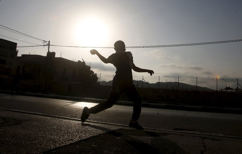 A Palestinian throws a stone at Israeli troops during clashes in Bethlehem, West Bank, on 5 October. Photo: CNS/Mussa Qawasma, Reuters