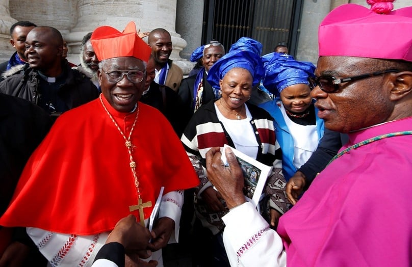 Nigerian Cardinal Francis Arinze, retired prefect of the Congregation for Divine Worship and the Sacraments, and Archbishop Valerian Okeke of Onitsha, Nigeria, gather for a group photo with Nigerian pilgrims after the closing Mass of the Synod of Bishops on the family on 25 October. Photo: CNS/Paul Haring