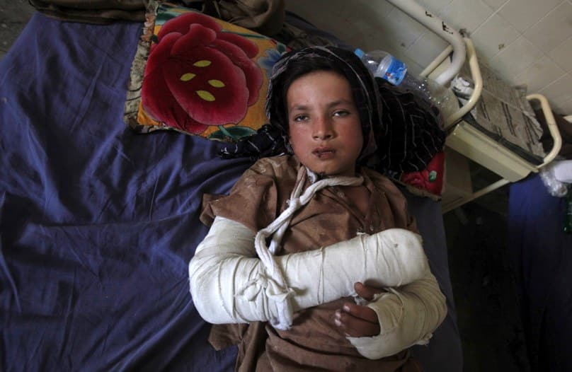 A boy lies in a bed after receiving aid at a hospital in Peshawar, Pakistan, following a magnitude-7.5 earthquake. Photo: CNS/Fayaz Aziz, Reuters