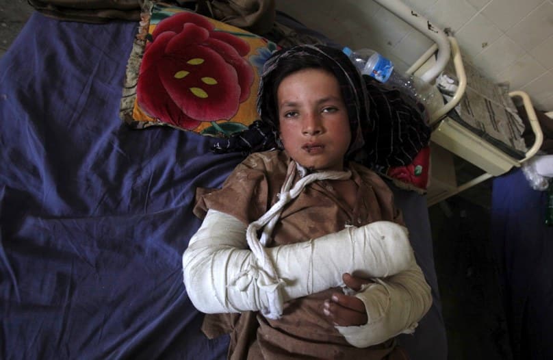 A boy lies in a bed after receiving aid at a hospital in Peshawar, Pakistan, following a magnitude-7.5 earthquake. Photo: CNS/Fayaz Aziz, Reuters 