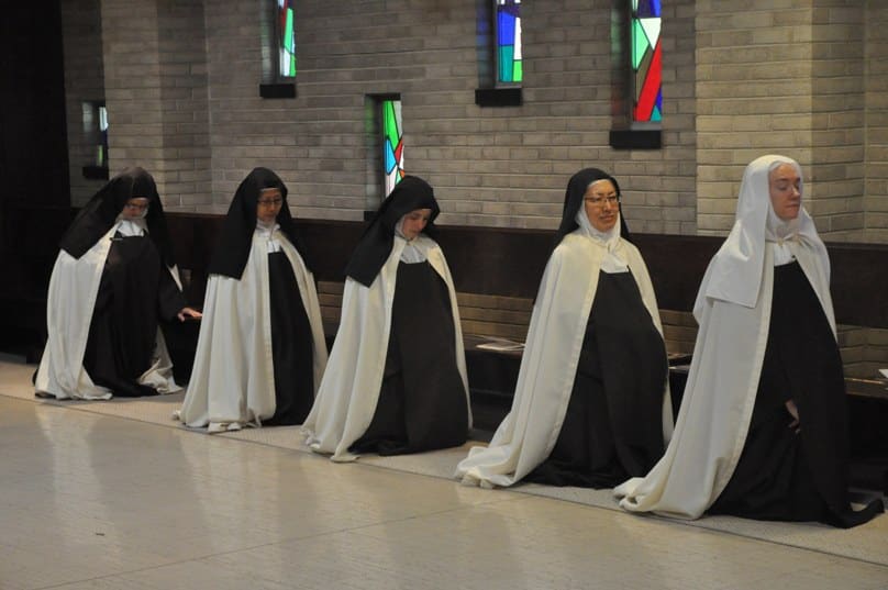 Discalced Carmelite Ss Mary Grace Melchior, Marianna So, Marie Cecile Franer, Susanna Choi and Christine Rosencrans kneel in prayer at the Carmelite Monastery of St Joseph in Indiana, during a 10 October Mass to celebrate the 500th anniversary of the birth of St Teresa of Avila, foundress of their order. Photo: CNS/Sean Gallagher, The Criterion