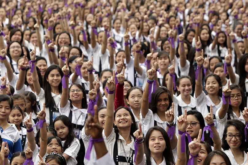 Philippine students inside an all-girl Catholic school in Manila, Philippines, demand an end to violence against women and girls. The purple ribbon has also been associated with a previous campaign in the Philippines to demand contraception rights. Photo: CNS