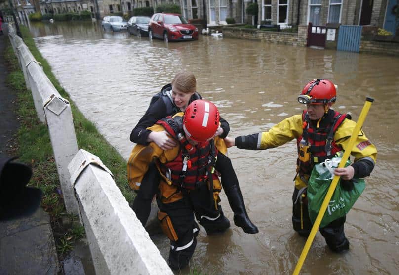 Members of the emergency services rescue a woman from a flooded property in York City Center in northern England. Photo: CNS/Andrew Yates, Reuters