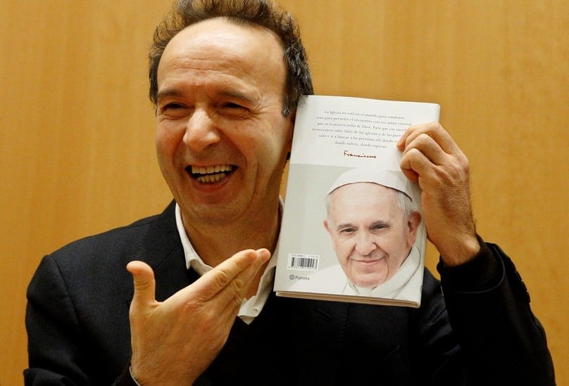 Italian actor Roberto Benigni holds a copy of The Name of God Is Mercy during its 12 January presentation to journalists in Rome. Photo: CNS