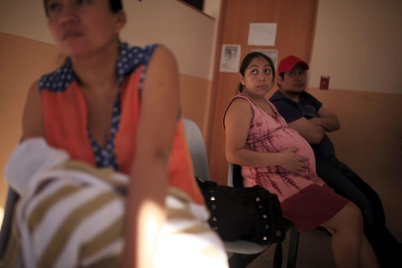 A pregnant woman waits to be seen at the Women's National Hospital in San Salvador, El Salvador. Health officials have urged women to postpone their pregnancies for two years, because the Zika virus can produce microcephaly, a rare neurological condition that causes smaller heads in newborns, affecting the normal development of their brain. Photo: CNS/Jose Cabezas, Reuters