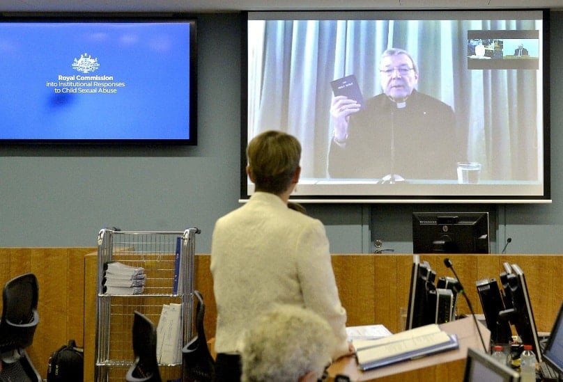 Gail Furness, senior counsel, stands in front of a screen displaying Cardinal George Pell as he holds a Bible while appearing via video link from a hotel in Rome, Italy, to testify at the Royal Commission Into Institutional Response to Child Sexual Abuse on 29 February. Photo: CNS/Reuters handout
