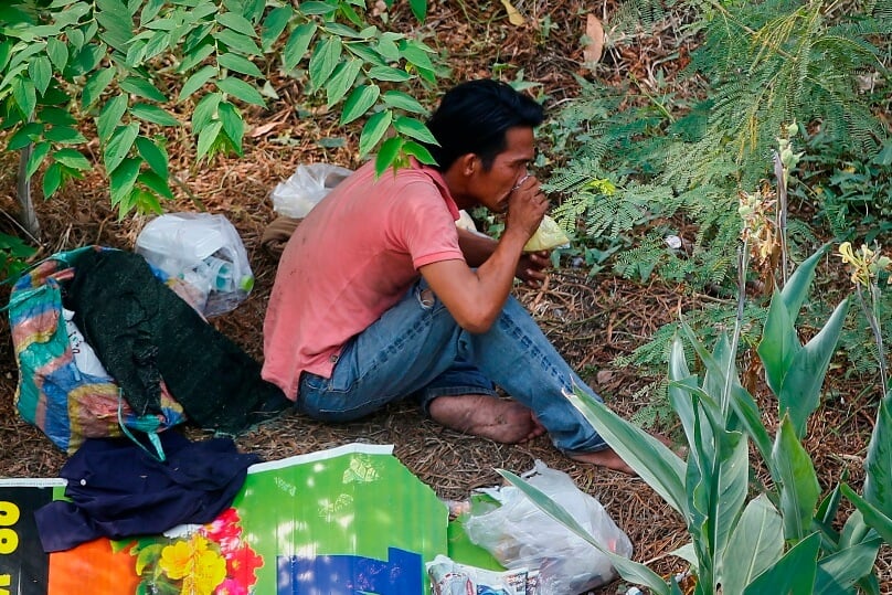 A man sniffs glue out of a plastic bag at an empty lot in Bangkok, Thailand, on 7 January. Photo: CNS/Diego Azubel, EPA