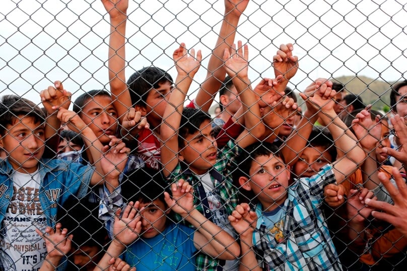 Syrian children stand at a fence on 23 April at a refugee camp near Gaziantep, Turkey. Catholics should protest against immigration policies that put the lives of children at risk, said Cardinal Vincent Nichols of Westminster, England. Photo: CNS/Sedat Suna, EPA