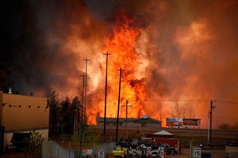 Flames from a wildfire rise in an industrial area of Fort McMurray in Alberta, Canada. The entire city has been evacuated because of the bushfire. Photo: CNS/CBC News via Reuters
