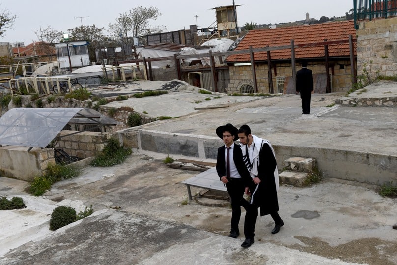 Orthodox Jewish men walk on the roof in the Arab section of the Old City of Jerusalem on their way from an Israeli settlement on 26 March. The Jewish settlement is near the Church of the Holy Sepulchre and the Church of the Redeemer in the Christian Quarter of the Old City. Photo: CNS/Debbie Hill