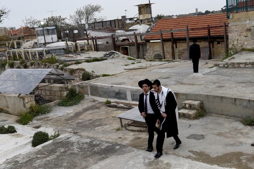 Orthodox Jewish men walk on the roof in the Arab section of the Old City of Jerusalem on their way from an Israeli settlement on 26 March. The Jewish settlement is near the Church of the Holy Sepulchre and the Church of the Redeemer in the Christian Quarter of the Old City. Photo: CNS/Debbie Hill