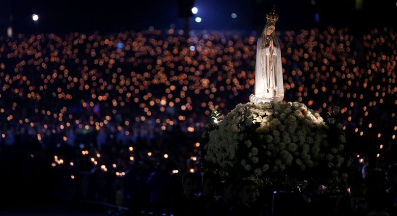 A statue of Our Lady of Fatima is carried through the crowd at the Marian shrine of Fatima in central Portugal on 12 May. Thousands of pilgrims arrived at the shrine to attend the 99th anniversary of the first apparition of Mary to three shepherd children. Lucia dos Santos and her cousins, Francisco and Jacinta Marto, received the first of several visions on 13 May, 1917. Photo: CNS/Rafael Marchante, Reuters