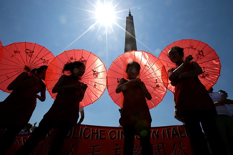 Young Chinese pilgrims shelter from the sun as Pope Francis leads the Angelus at the Vatican on 22 May. Photo: CNS
