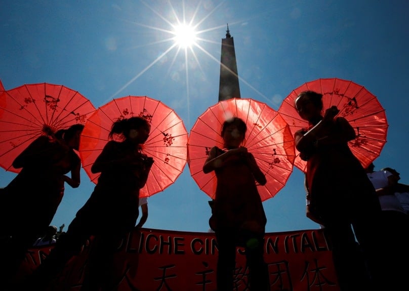 Young Chinese pilgrims shelter from the sun as Pope Francis leads the Angelus from his studio overlooking St Peter's Square at the Vatican on 22 May. Photo: CNS/Max Rossi, Reuters