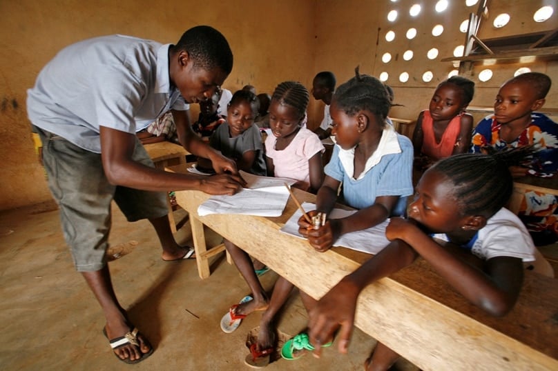 An English teacher works with children in 2010 at a school in Pujehun, Sierra Leone. Fr Peter Konteh has appealed to the sponsors of the new U.N. educational initiative to help the children of Sierra Leone, victims of a bloody 10-year civil war and more lately Ebola, return to school. Photo: CNS/Ahmed Jallanzo, EPA