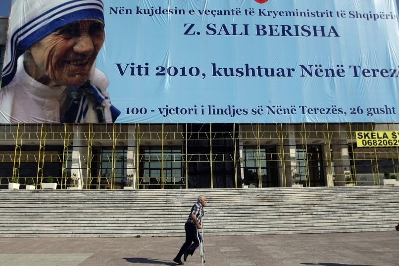 A man on crutches passes a large banner of Blessed Teresa of Kolkata in 2010 in Tirana, Albania. Mother Teresa, founder of the Missionaries of Charity who won the Nobel Peace Prize in 1979, will become a saint on 4  September. Photo: CNS/Armando Babani, EPA