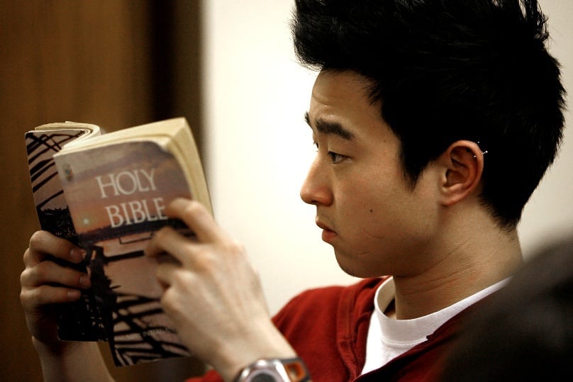A young man is seen reading a Bible in 2010. A new State of the Bible Survey by the American Bible Society found that 77 per cent of American Catholics want to read the Bible more often. Photo: CNS/Karen Callaway, Catholic New World