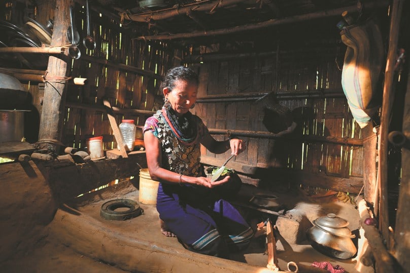 A Bru tribal woman prepares food in a refugee camp in Kanchanpur, India, on 18 June, the eve of World Refugee Day. Photo: EPA