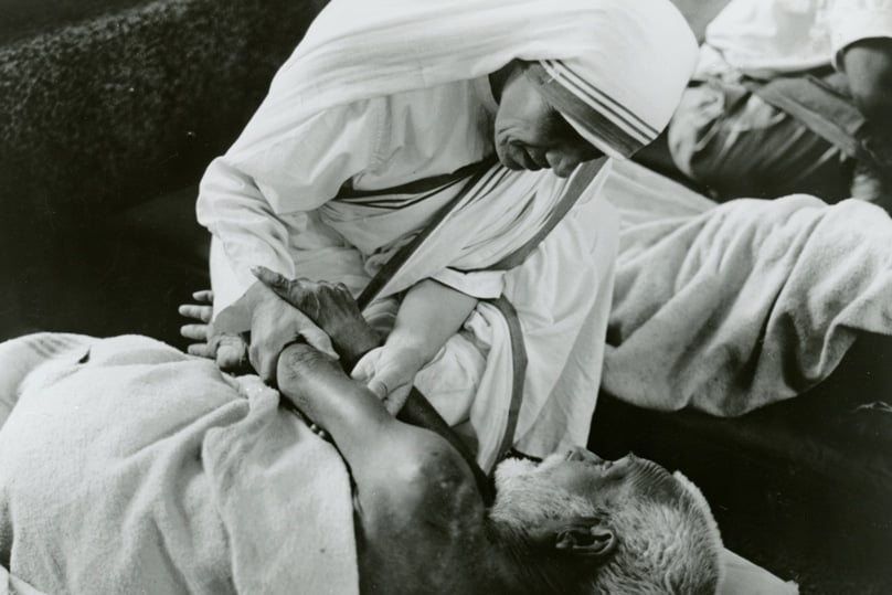 Mother Teresa greets a dying man. Photo: CNS