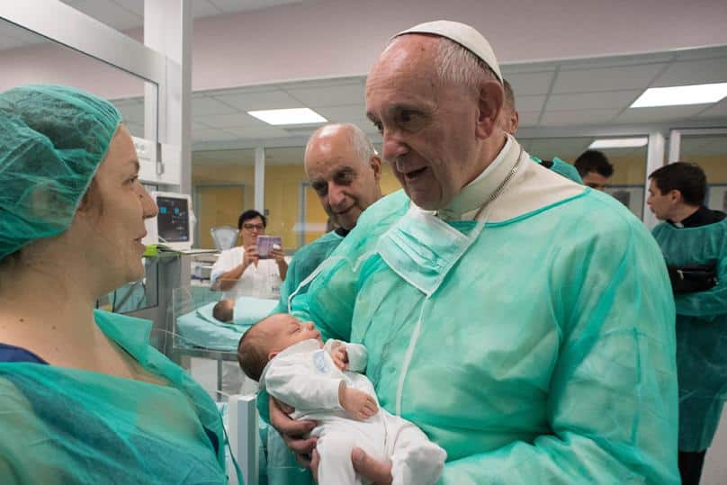 Pope Francis holds a baby as he visits the neonatal unit at San Giovanni Hospital in Rome on 16 September. The visit was part of the pope's series of Friday works of mercy during the Holy Year. Photo: CNS/L'Osservatore Romano