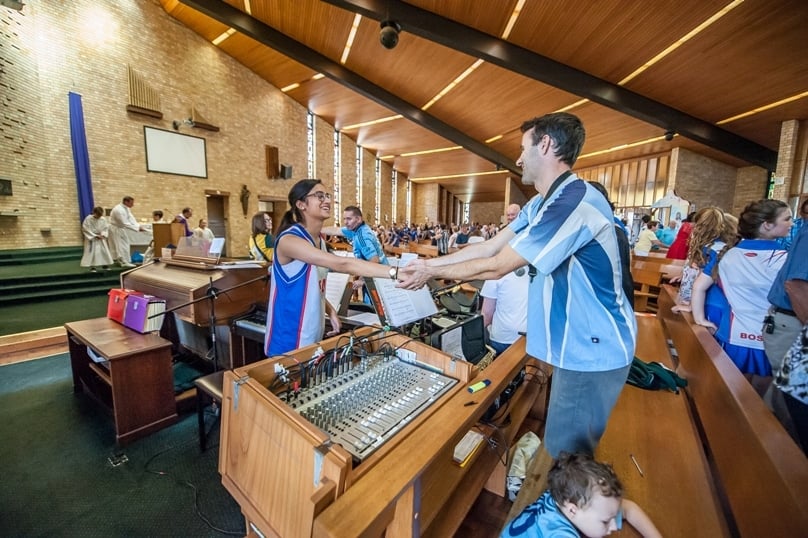 Parishioners share the sign of peace during Mass. Photo: Giovanni Portelli