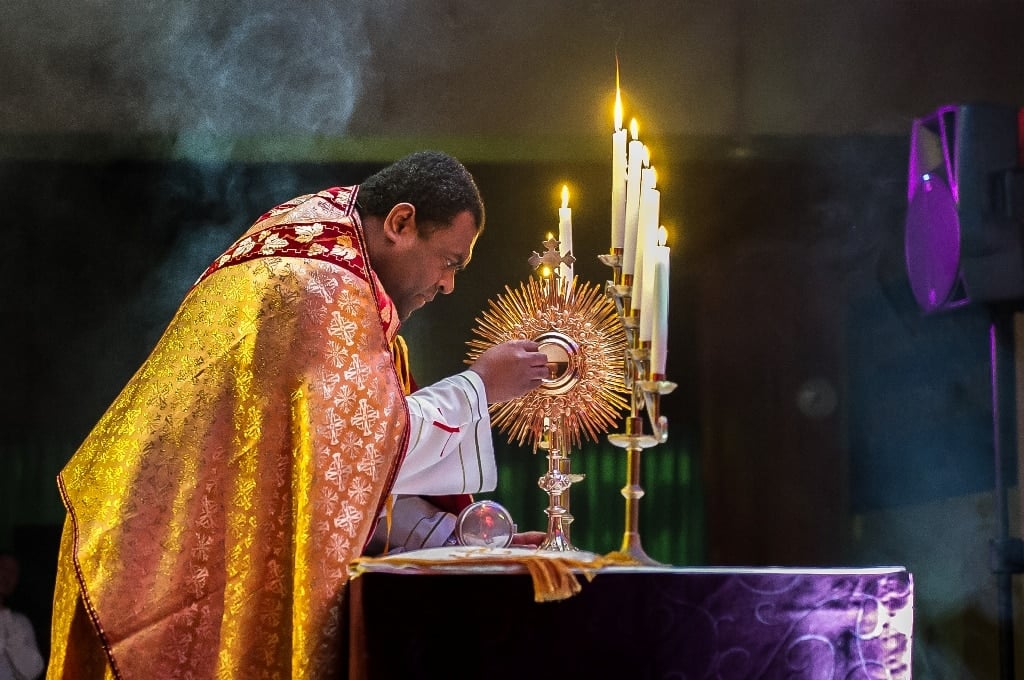 Fr Epeli places Eucharist in the monstrance during adoration at St Joachim's church, Lidcombe, during Gracefest 2015. Photo: Giovanni Portelli