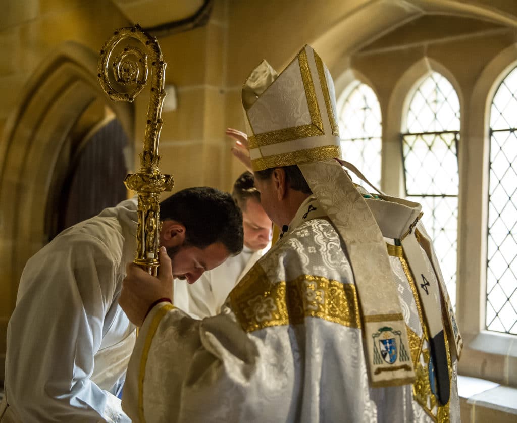 Archbishop Anthony Fisher OP prays over deacons Barakat and Stevens before last weekend’s ordinations. Photo: Giovanni Portelli