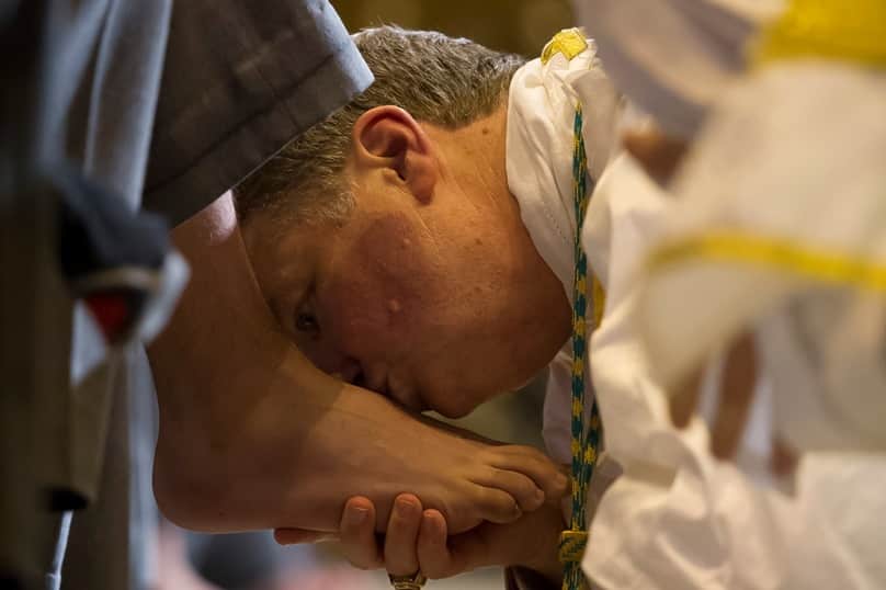 Archbishop Anthony Fisher OP washing and kissing the feet of a member of the faithful at Holy Thursday celebrations at St Mary's Cathedral in 2015. Photo: Giovanni Portelli