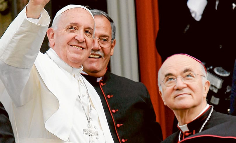 Pope Francis in 2015 waves alongside Archbishop Carlo Maria Vigano, then the Apostolic Nuncio to the United States, right, outside St. Patrick in the City Church in Washington. PHOTO: CNS photo/Bob Roller