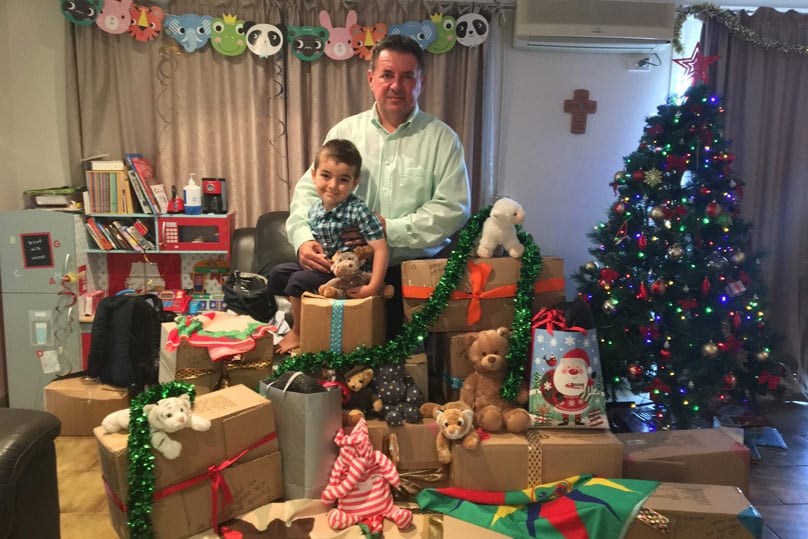 Milan Maksimovic and his five-year-old son Christian with hampers containing food, toys and clothing to help refugee families over Christmas and New Years Seasons in 2018.