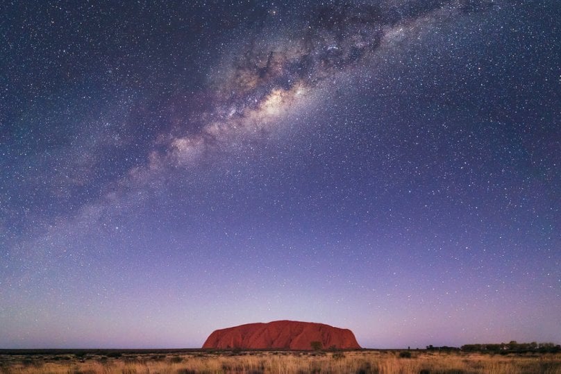Uluru at night, beneath the magnificent panorama of the Milky Way. Photo: Luke Tscharke