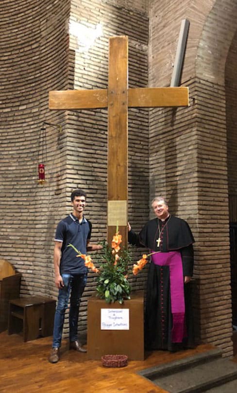 Archbishop Anthony Fisher OP of Sydney stands besides the original World Youth Day Cross with Australian synod observer, Sebastian Duhau.