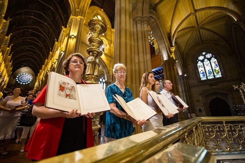 Catechumens and sponsors hold the Book of the Elect in St Mary’s Cathedral earlier this year. Photo: Giovanni Portelli