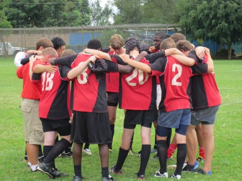 Members of a student rugby team pray together before their match.