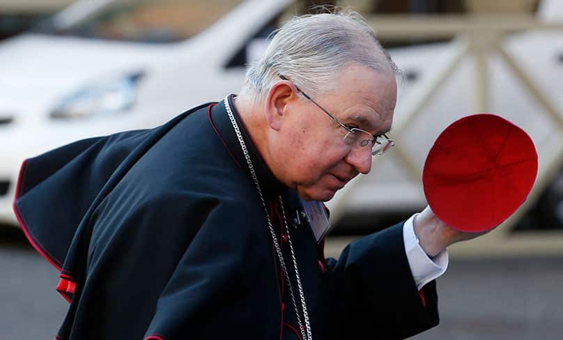 Archbishop Jose H. Gomez of Los Angeles, vice president of the conference, holds onto his zucchetto in windy conditions as he arrives for a session of the Synod of Bishops on Youth. Photo: CNS photo/Paul Haring