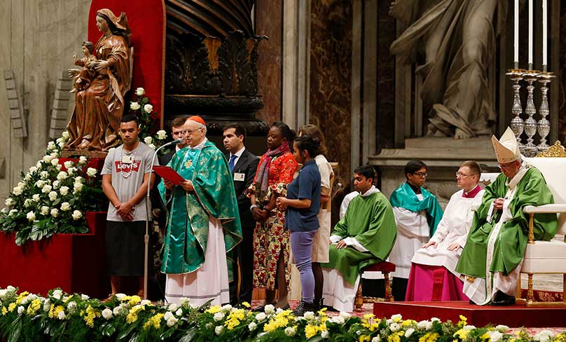 Pope Francis looks on as Cardinal Lorenzo Baldisseri, secretary-general of the Synod of Bishops, reads a letter from the synod fathers to young people during the closing Mass of the Synod of Bishops on young people, the faith and vocational discernment in St. Peter's Basilica at the Vatican on 28 October. photo: CNS photo/Paul Haring